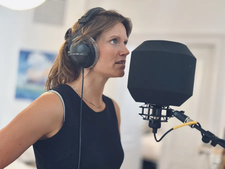 Randi Gustafsson synger i et studie med hovedtelefoner foran en mikrofon